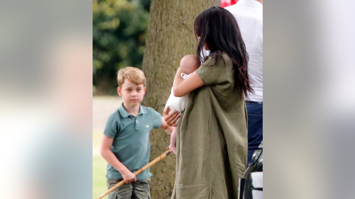 Prince George of Cambridge, Meghan, Duchess of Sussex and Archie Harrison Mountbatten-Windsor attend the King Power Royal Charity Polo Match