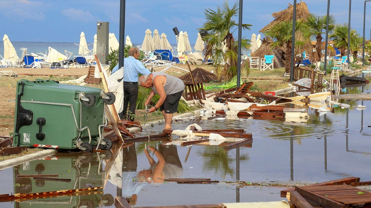 Two men search in debris after a storm at Nea Plagia village in Halkidiki region, northern Greece on Thursday, July 11, 2019.