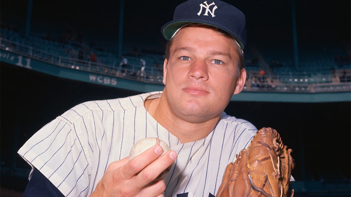 New York Yankee pitcher Jim Bouton wearing his glove and holding a baseball.