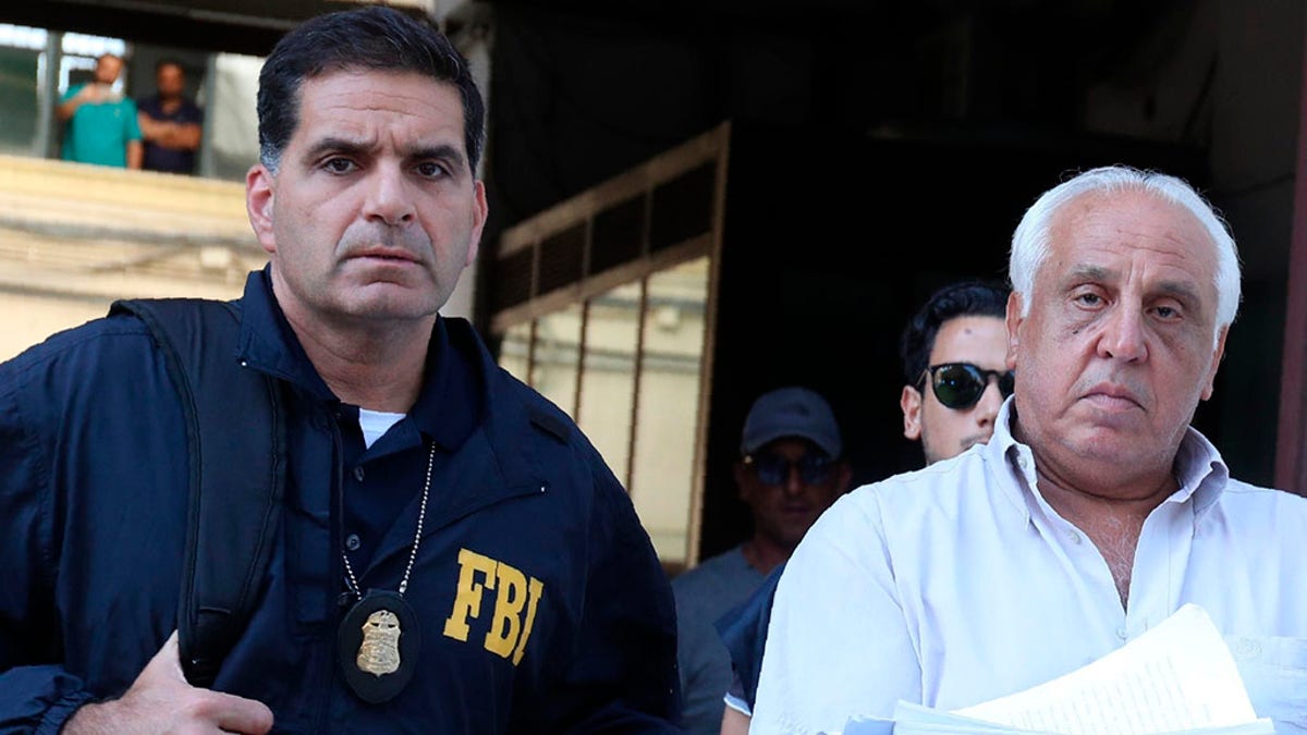 Suspect Tommaso Inzerillo, right, is taken into custody during an anti-mafia operation lead by the Italian Police and the FBI in Palermo, Southern Italy, Wednesday, July 17, 2019. Italian police and the FBI arrested 19 suspected Mafiosi in a joint operation Wednesday following an investigation which revealed alleged ties between Sicily's Cosa Nostra Mafia and New York's Gambino crime family.