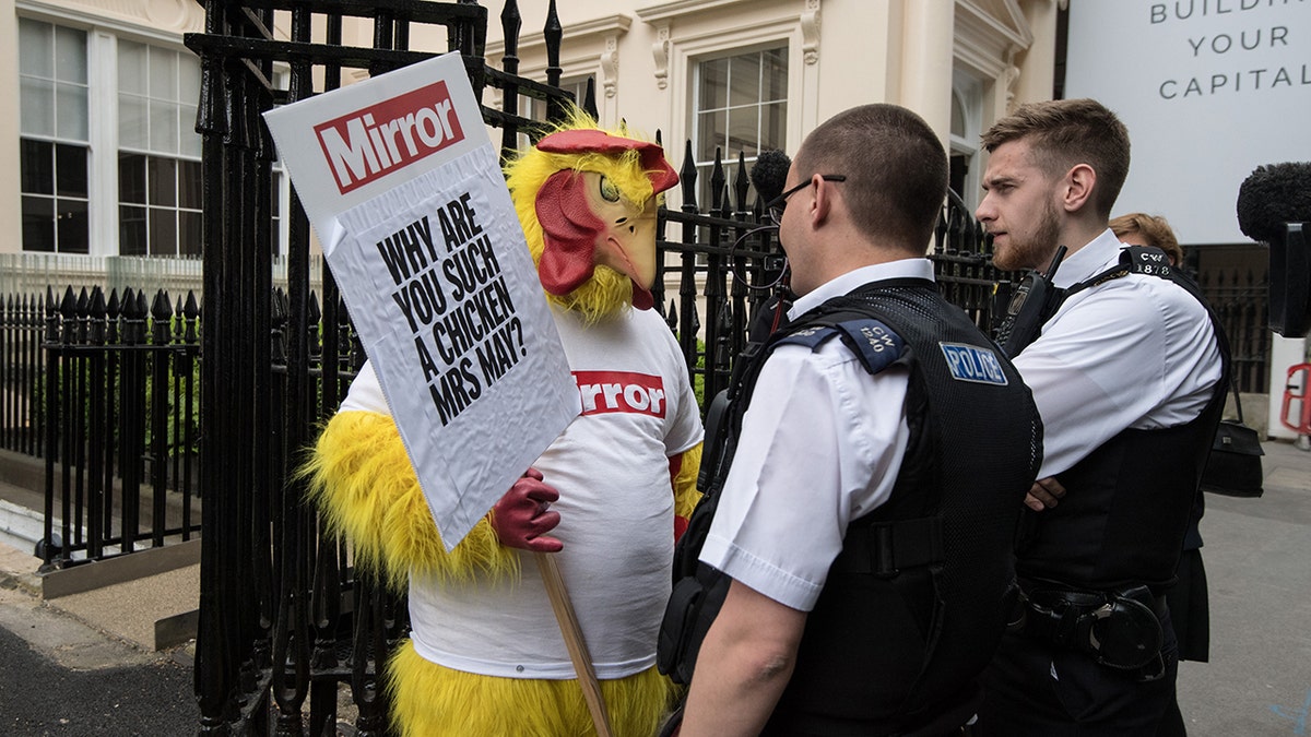 Police officers speak to a Daily Mirror campaigner dressed as a chicken outside a venue where then Chancellor of the Exchequer, Philip Hammond and Secretary of State for Exiting the European Union, David Davis, were due to speak