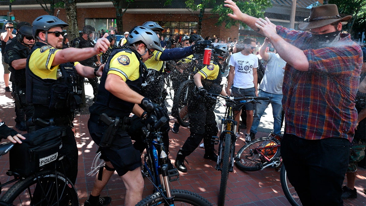 After a confrontation between authorities and protesters, police use pepper spray as multiple groups, including Rose City Antifa, the Proud Boys and others protest in downtown Portland, Ore., on June 29, 2019.