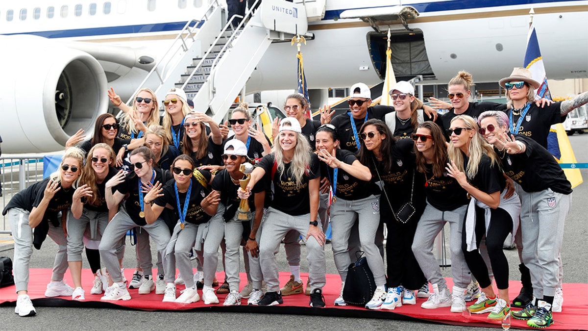 The U.S. women's soccer team posing with the World Cup trophy after arriving at Newark Liberty International Airport on Monday. 
