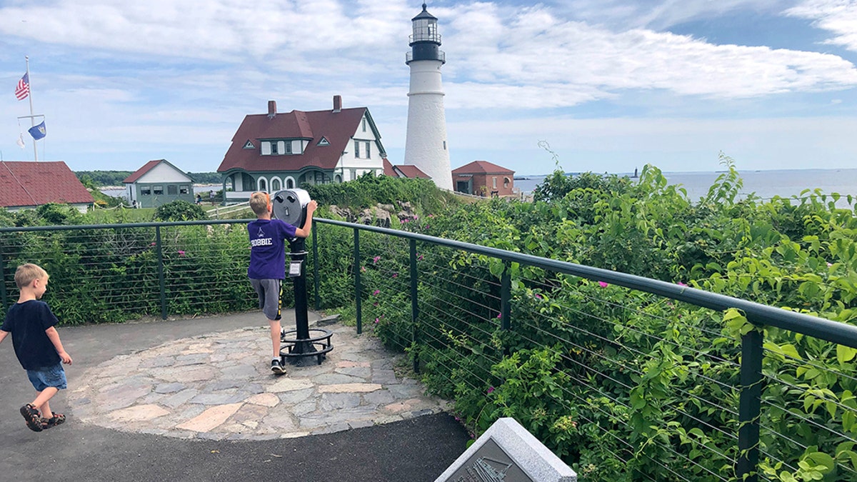 Children take in the view at Fort Williams Park at Cape Elizabeth, Maine, on Thursday, July 18, 2019, where a plaque, foreground, remembers those killed when the USS Eagle PE-56 was sunk During World War II off the Maine coast on April 23, 1945.