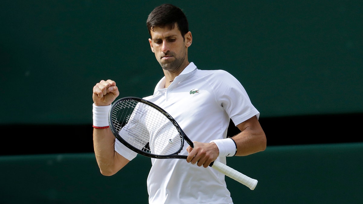 Serbia's Novak Djokovic reacts after scoring a point in the 3rd set tiebreak with Switzerland's Roger Federer during the men's singles final match of the Wimbledon Tennis Championships in London, Sunday, July 14, 2019. (AP Photo/Ben Curtis)