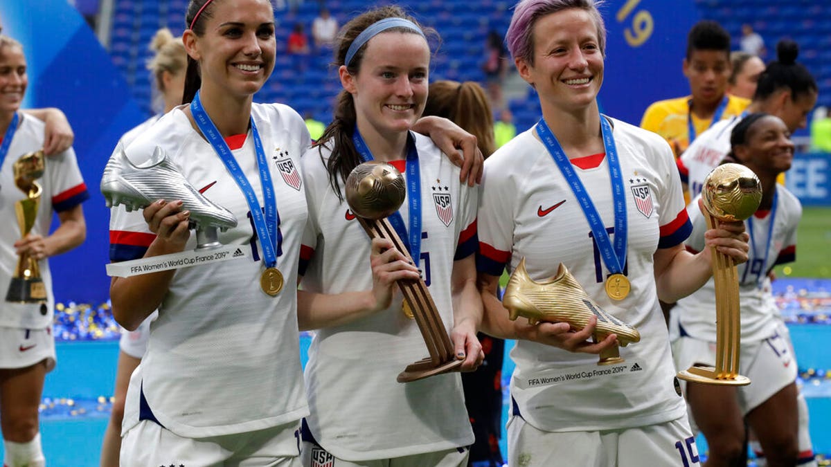 United States' Megan Rapinoe, right, United States' Alex Morgan, left, and United States' Rose Lavelle, center, pose with their trophies after the Women's World Cup final soccer match between US and The Netherlands. (AP Photo/Alessandra Tarantino)