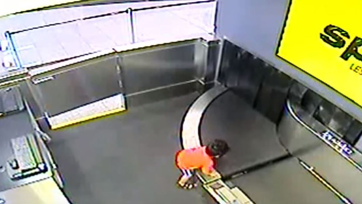 Airport surveillance video shows the boy climbing onto the conveyor belt.