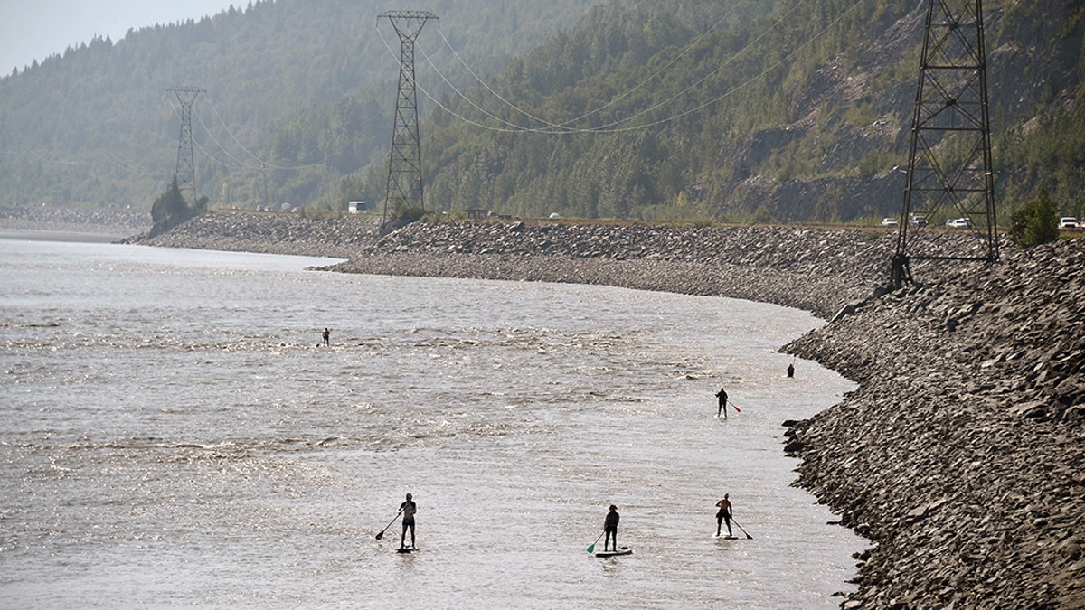 ANCHORAGE, AK - JULY 04: People navigate the Turnagain Arm on paddle boards as vehicles move along the Seward Highway on July 4, 2019 south of Anchorage, Alaska. Alaska is bracing for record warm temperatures and dry conditions in parts of the state. (Photo by Lance King/Getty Images)