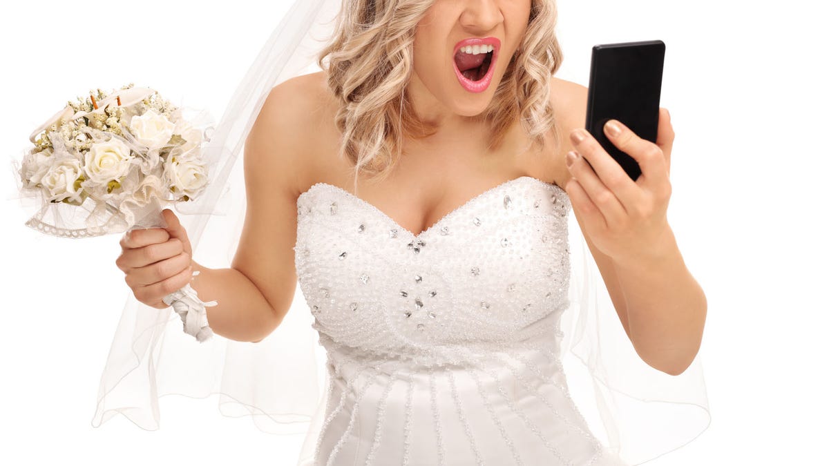 Furious bride looking at her phone
