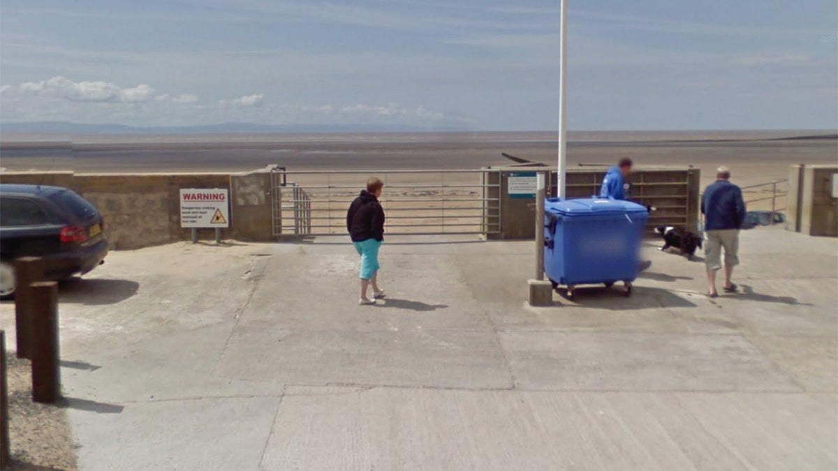 A sign at the entrance to the beach warns drivers about the tides.