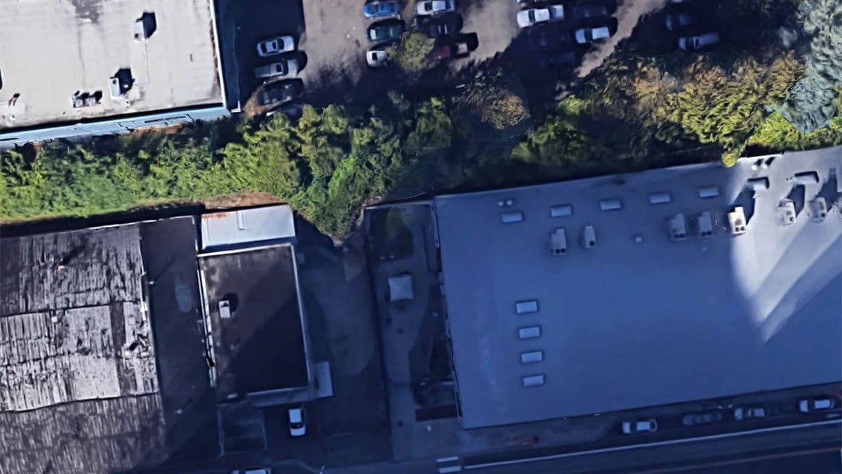 The playground is directly in line with an aisle of the parking lot above it.