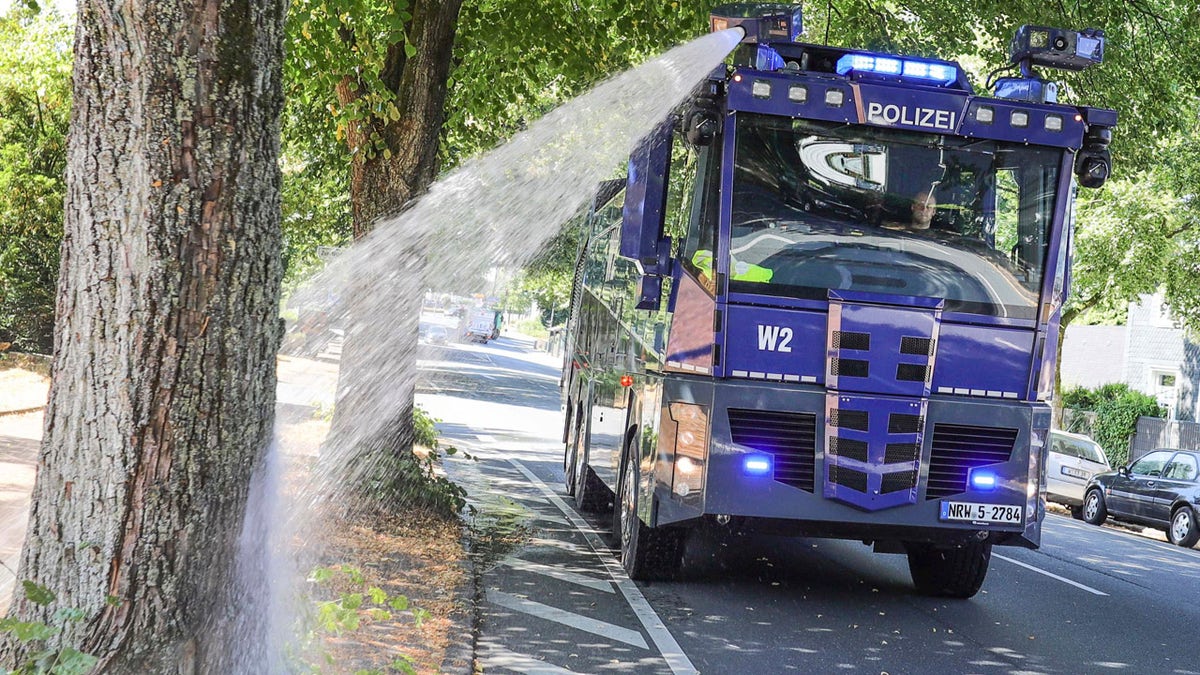 A water cannon of the German police waters trees in Wuppertal, western Germany, Wednesday, July 24, 2019. Hot temperatures are expected all over Europe during the next days.