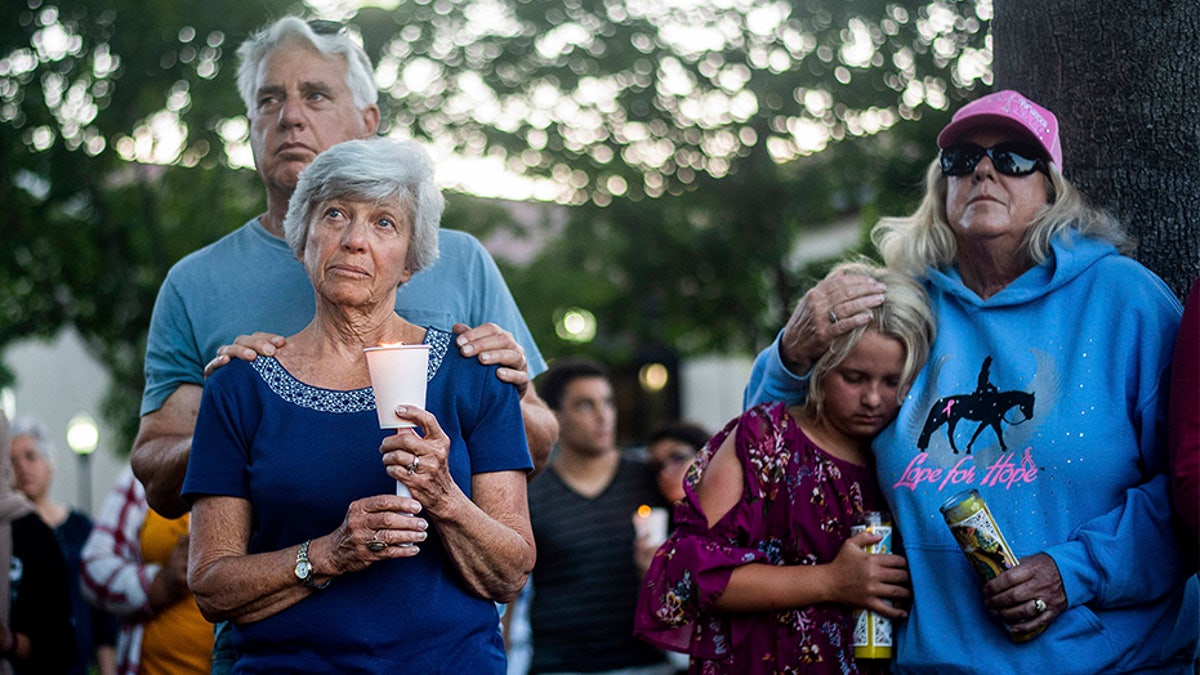 Susan Meyers and husband Michael Oshan listen to a hymn during a vigil Monday for victims of the shooting. (AP)