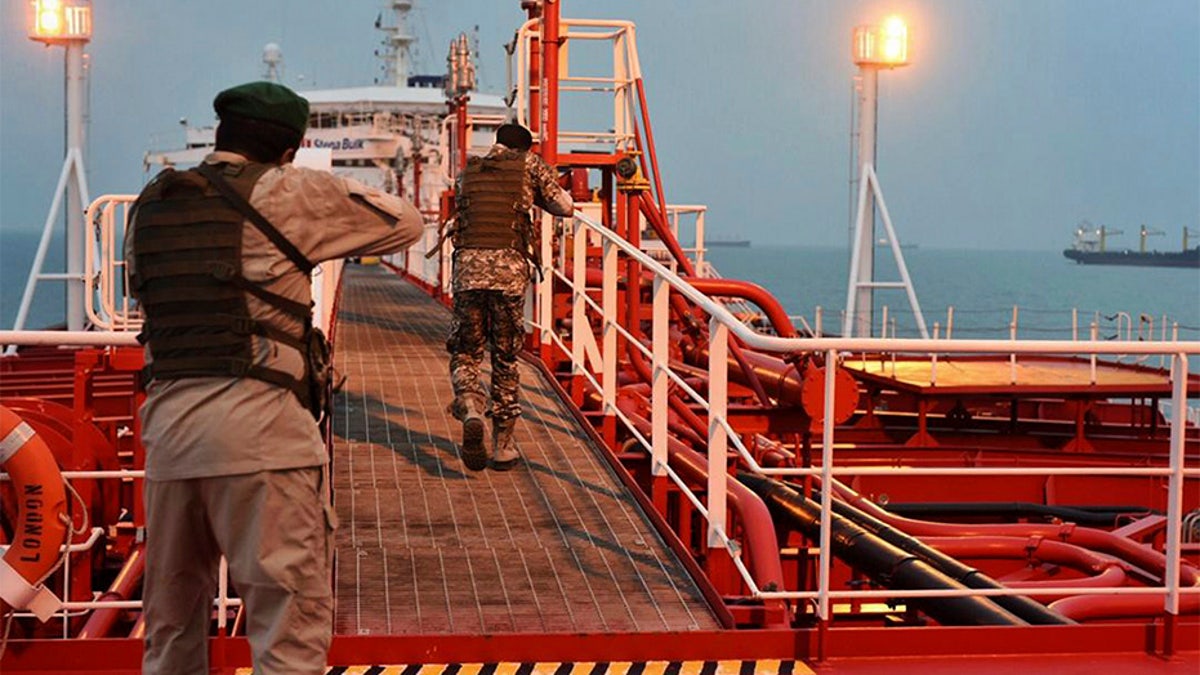 Two armed members of Iran's Revolutionary Guard inspect the British-flagged oil tanker Stena Impero, which was seized in the Strait of Hormuz on Friday by the Guard, in the Iranian port of Bandar Abbas. (AP/Mehr News Agency)