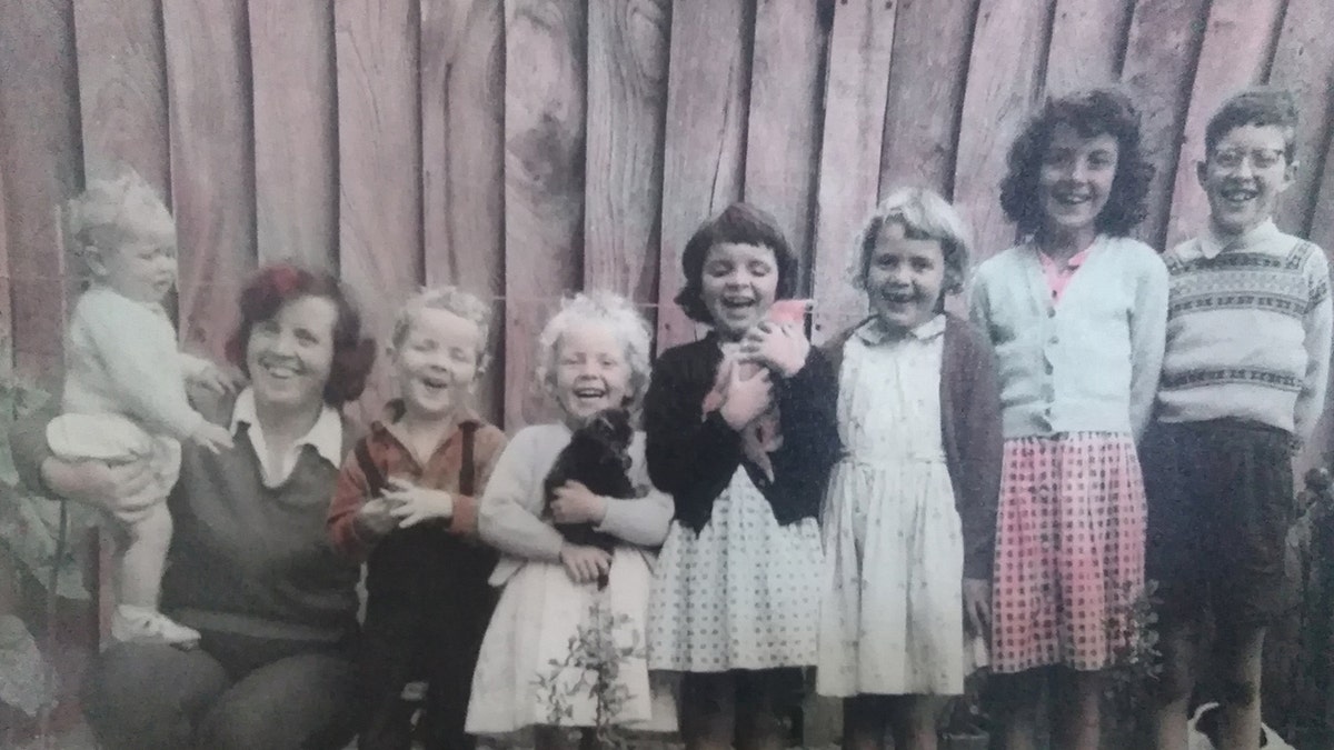 A family photo of Aldrin standing on his mother Diana West's leg with his brothers and sisters.