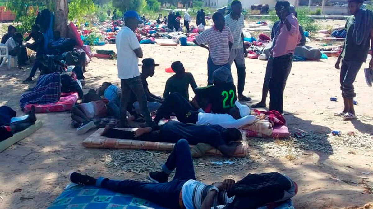 People rest outside at the detention center following the airstrike, which killed at least 44 migrants. (AP)