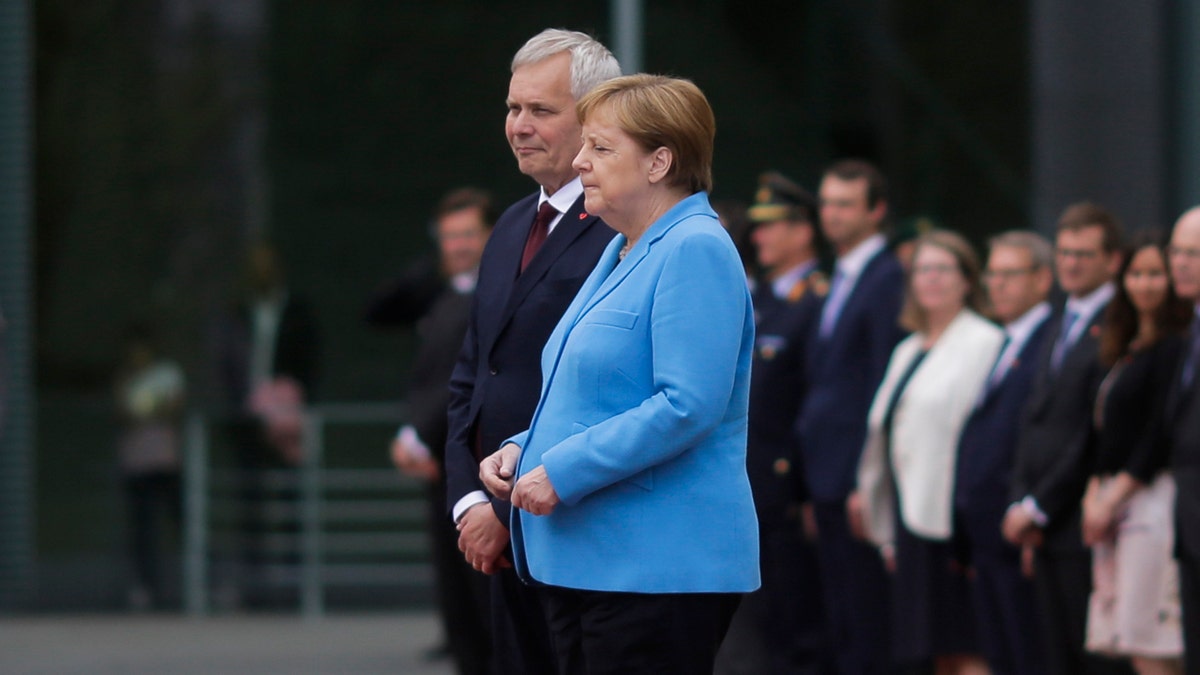 German Chancellor Angela Merkel and Prime Minister of Finland Antti Rinne listen to the national anthems at the chancellery in Berlin, Germany, Wednesday, July 10, 2019. (AP Photo/Markus Schreiber)