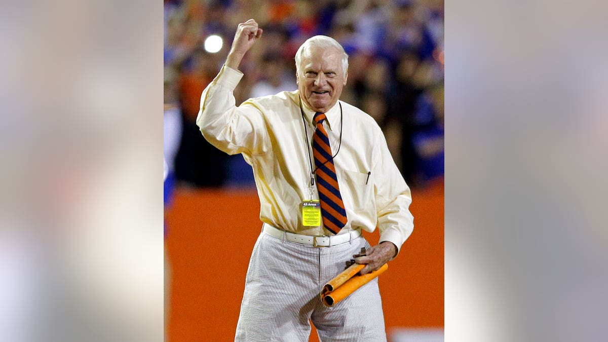 FILW - In this Nov. 26, 2011, file photo, George Edmondson Jr., known to the University of Florida community as "Mr. Two Bits," leads a cheer on the field before the first half of an NCAA college football game in Gainesville, Fla. The University of Florida's most famous cheerleader has died at age 97. The school announced Edmondson Jr.’s death two days after his passing. Edmondson was better known as "Mr. Two Bits" while riling up crowds at Florida home games for nearly 60 years. (AP Photo/John Raoux, File)