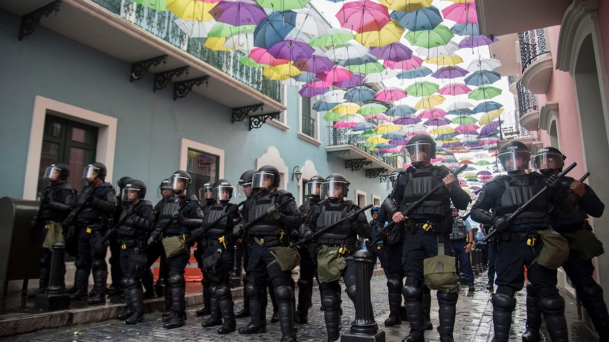 Police block protesters from advancing to La Fortaleza governor's residence in San Juan, Puerto Rico, Sunday. Protesters demanded Gov. Ricardo Rosselló step down for his involvement in a private chat in which he used profanities. (AP Photo/Carlos Giusti)