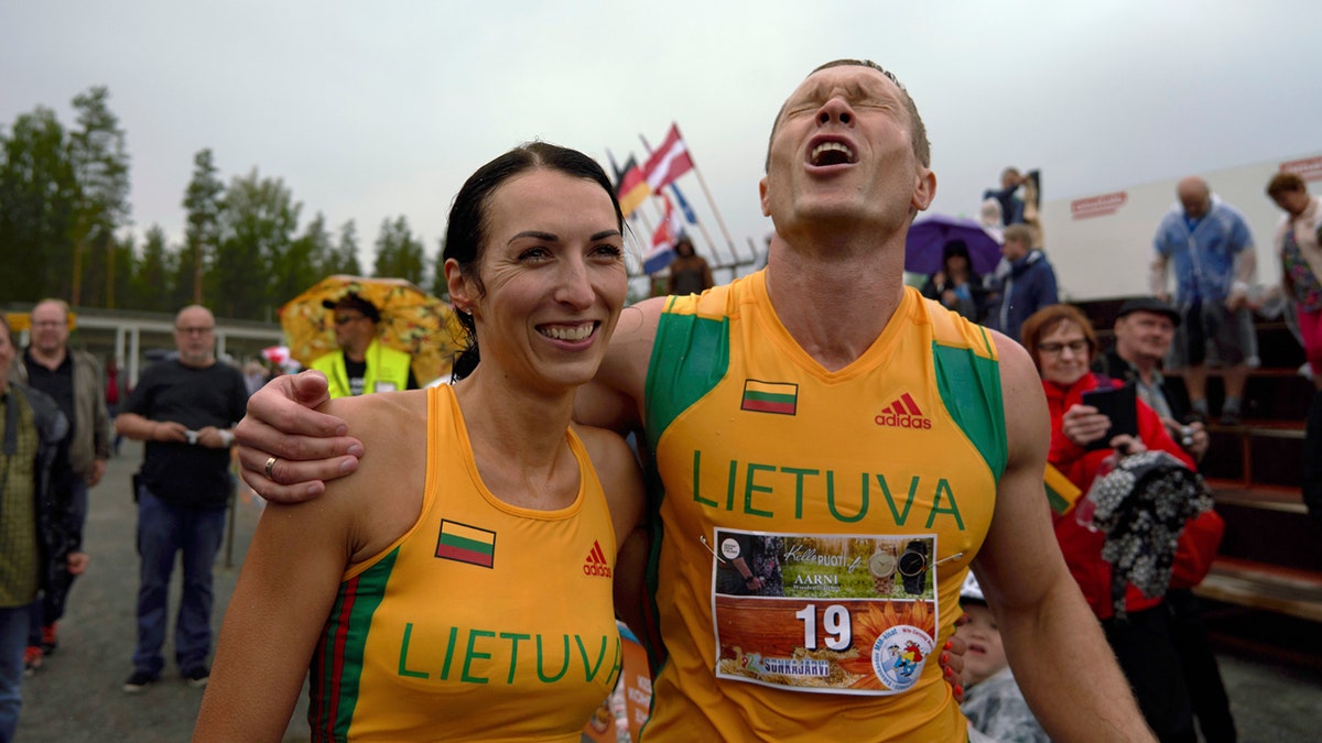 Lithuanian couple Vytautas Kirkliauskas, right, and Neringa Kirkliauskiene celebrate their victory in the wife carrying race, a 278-yard obstacle course, during the 24th world championships in Sonkajarvi, Finland, Saturday, July 6, 2019. (AP Photo/David Keyton)