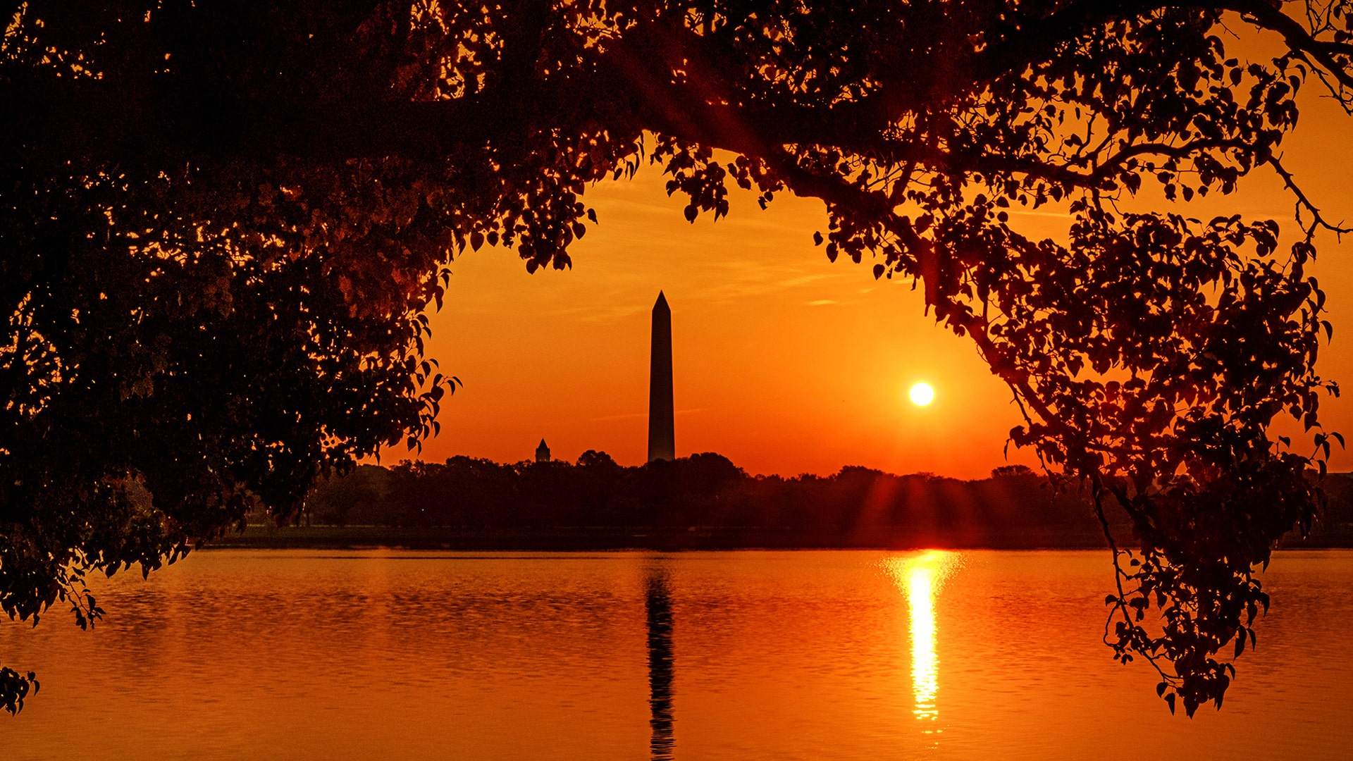 The Washington Monument is silhouetted against the morning sky as the sun rises at the start of a hot day in Washington, July 20, 2019. 