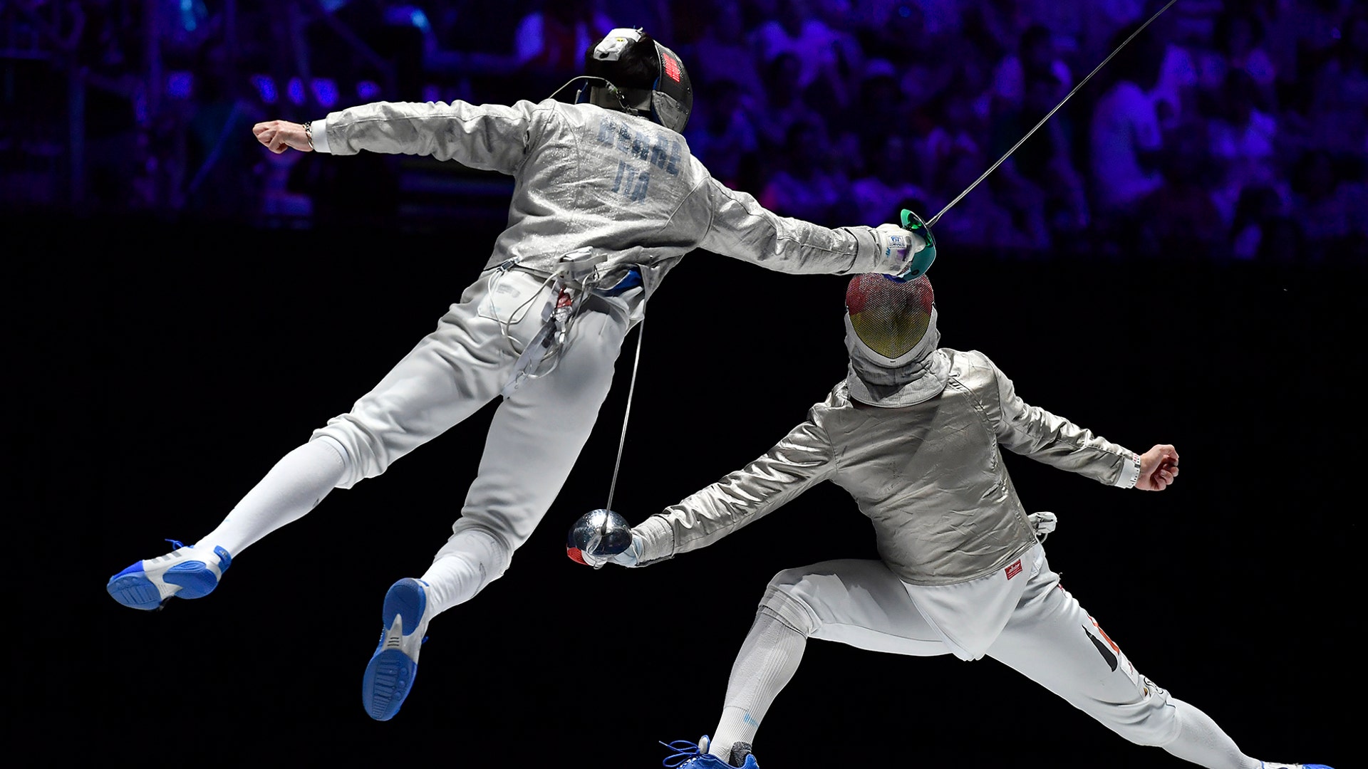 Enrico Berre of Italy and Matyas Szabo of Germany fight in the men's team sabre bronze medal match of the FIE World Fencing Championships in Budapest, Hungary, July 21, 2019. 