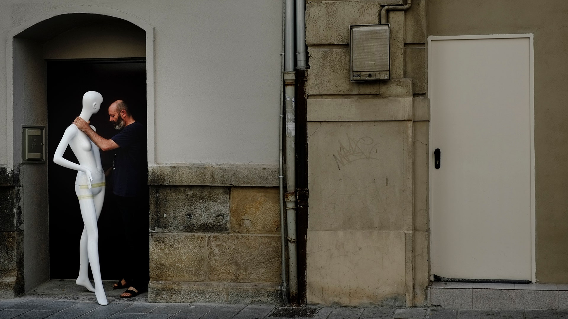 A man stands with a mannequin in a doorway in Pamplona, northern Spain, July 22, 2019. 