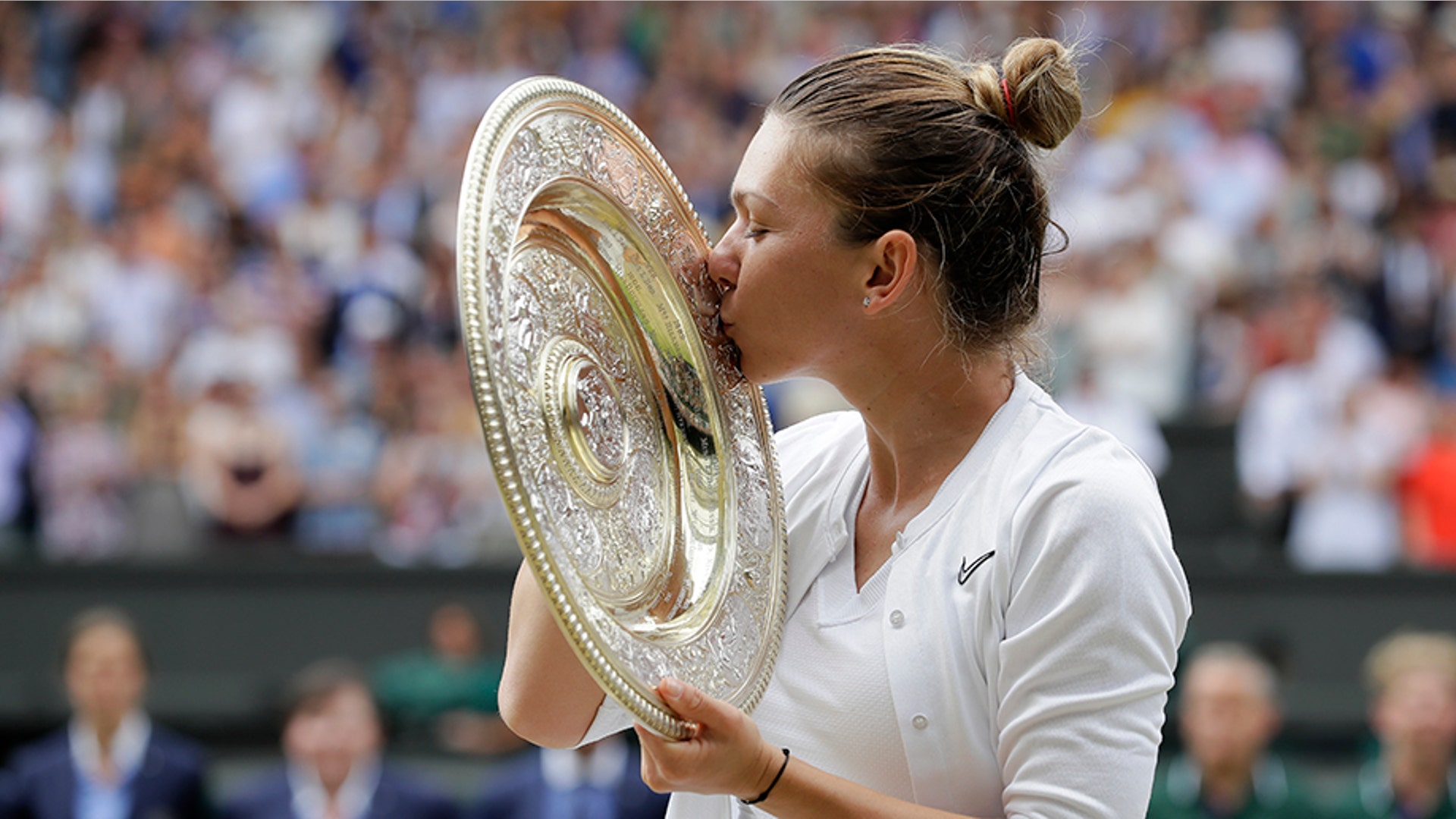 Romania's Simona Halep kisses the trophy after defeating Serena Williams in the women's singles final at the Wimbledon Tennis Championships in London, July 13, 2019. 