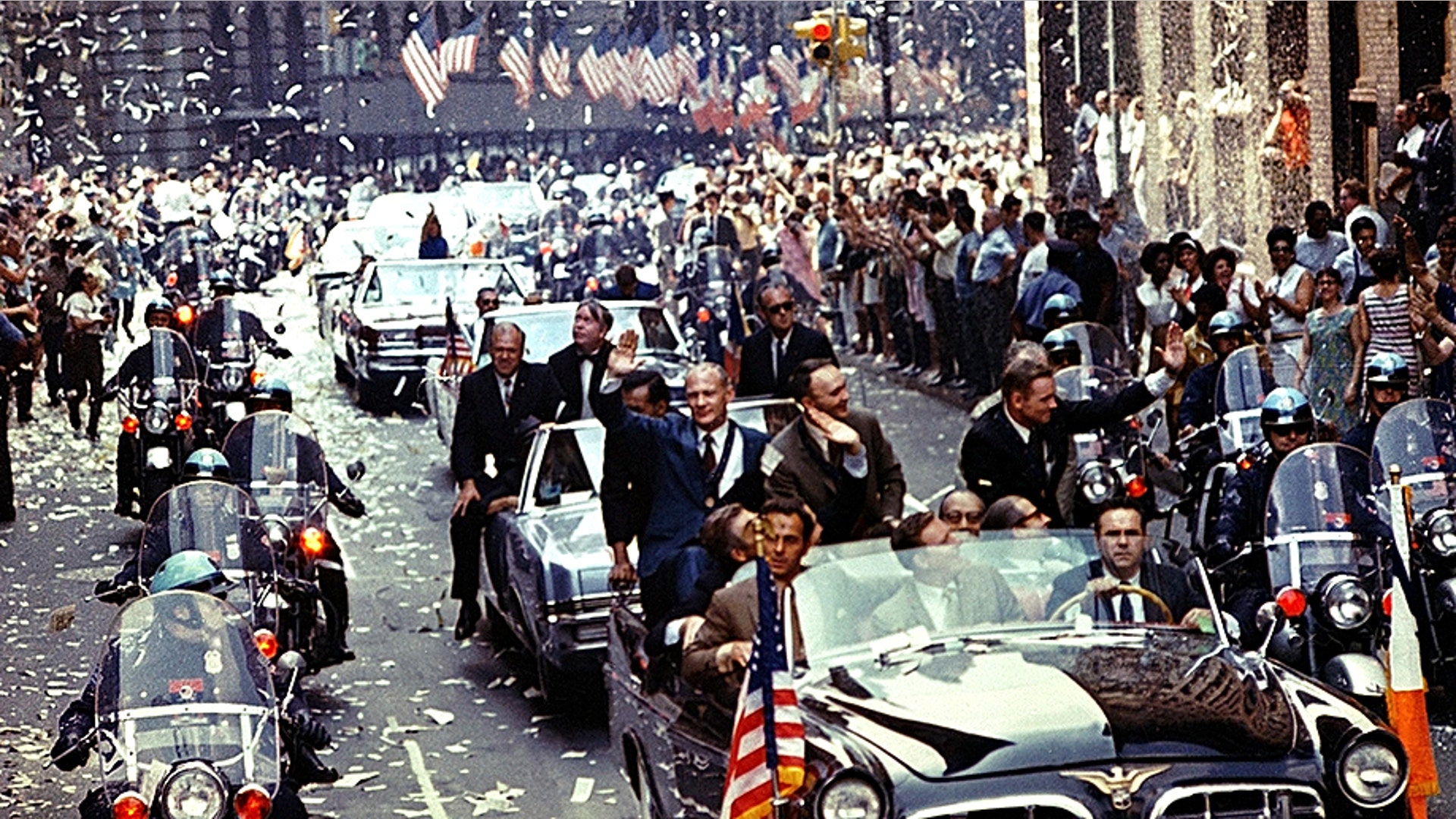New York City welcomes Apollo 11 crewmen in a showering of ticker tape down Broadway and Park Avenue in a parade termed as the largest in the city's history. Pictured in the lead car are astronauts Neil Armstrong, commander; Michael Collins, command module pilot; and Edwin E. Aldrin Jr., lunar module pilot.