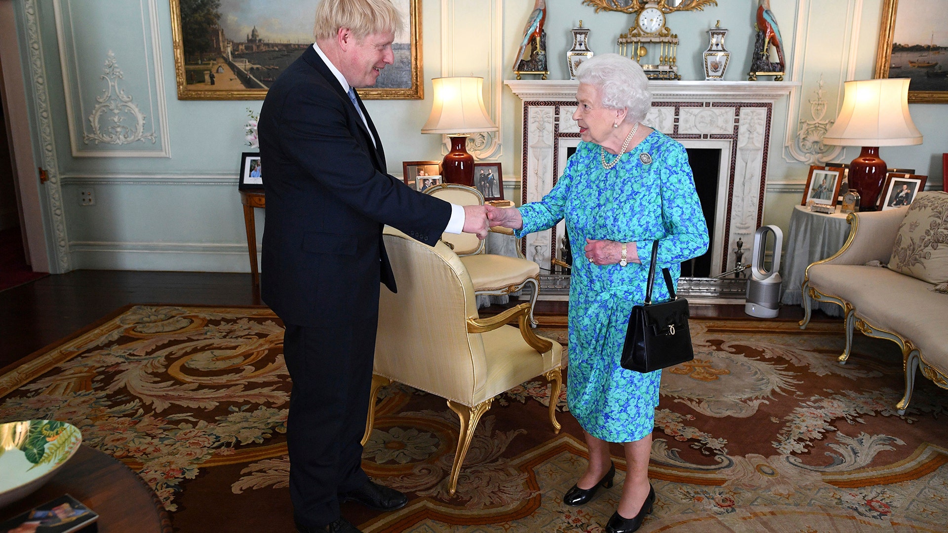 Britain's Queen Elizabeth II welcomes newly elected leader of the Conservative party Boris Johnson during an audience at Buckingham Palace where she invited him to become Prime Minister in London, July 24, 2019. 