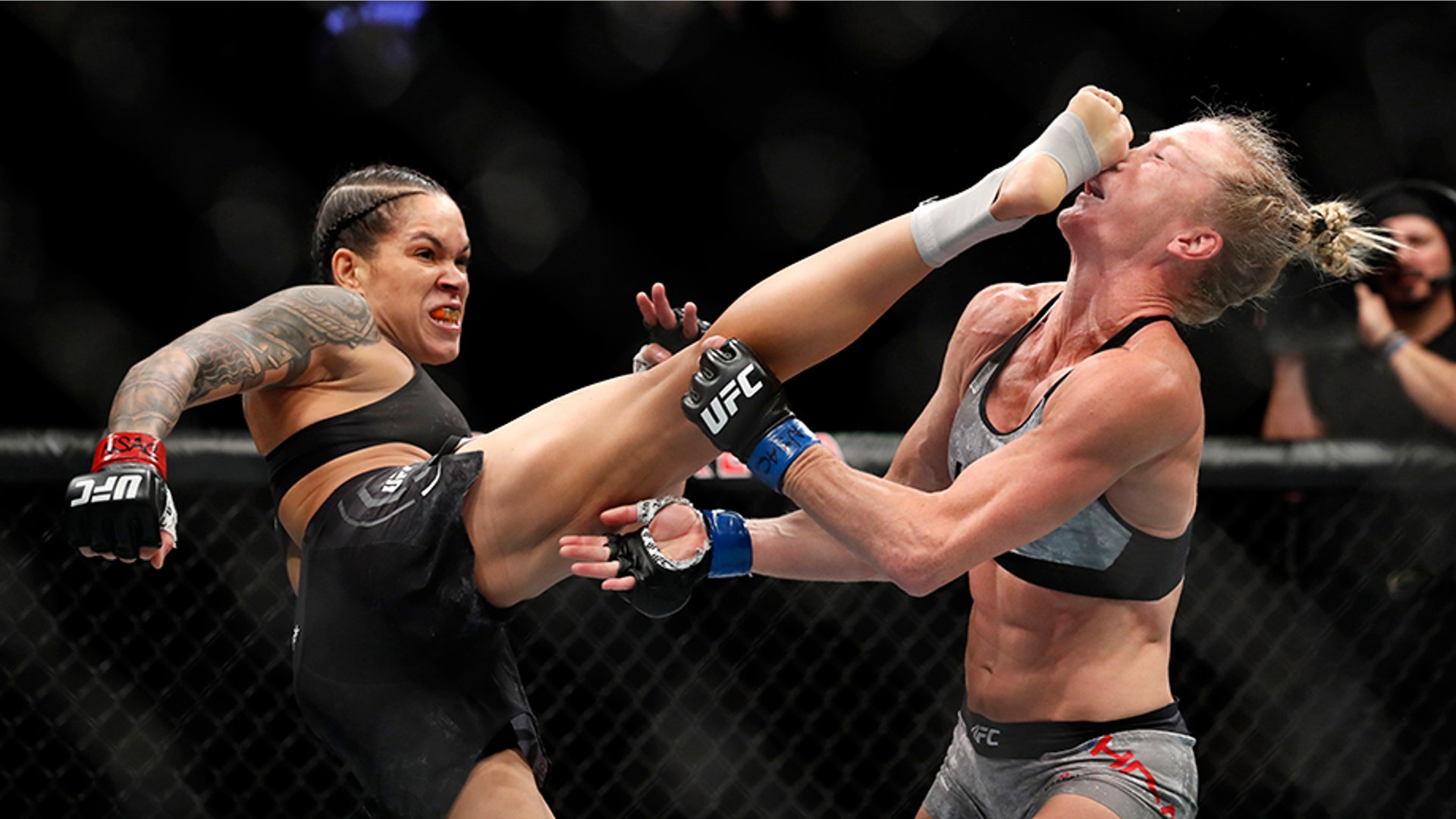 Amanda Nunes of Brazil lands a kick on Holly Holms that knocked her to the mat in the first round of their bantamweight title mixed martial arts bout during UFC 239 in Las Vegas, July 6, 2019.  (Steve Marcus/Las Vegas Sun via AP)