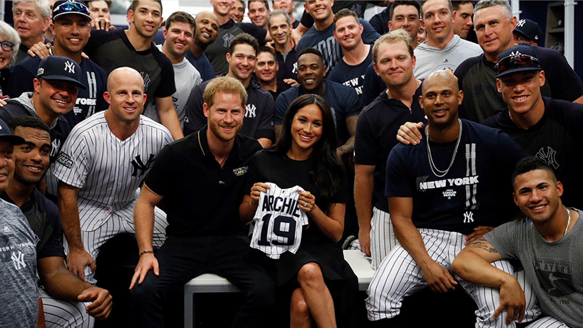 Britain's Prince Harry and Meghan, Duchess of Sussex pose for a picture with players of the New York Yankees before their game against the Boston Red Sox in London, June 29, 2019. 