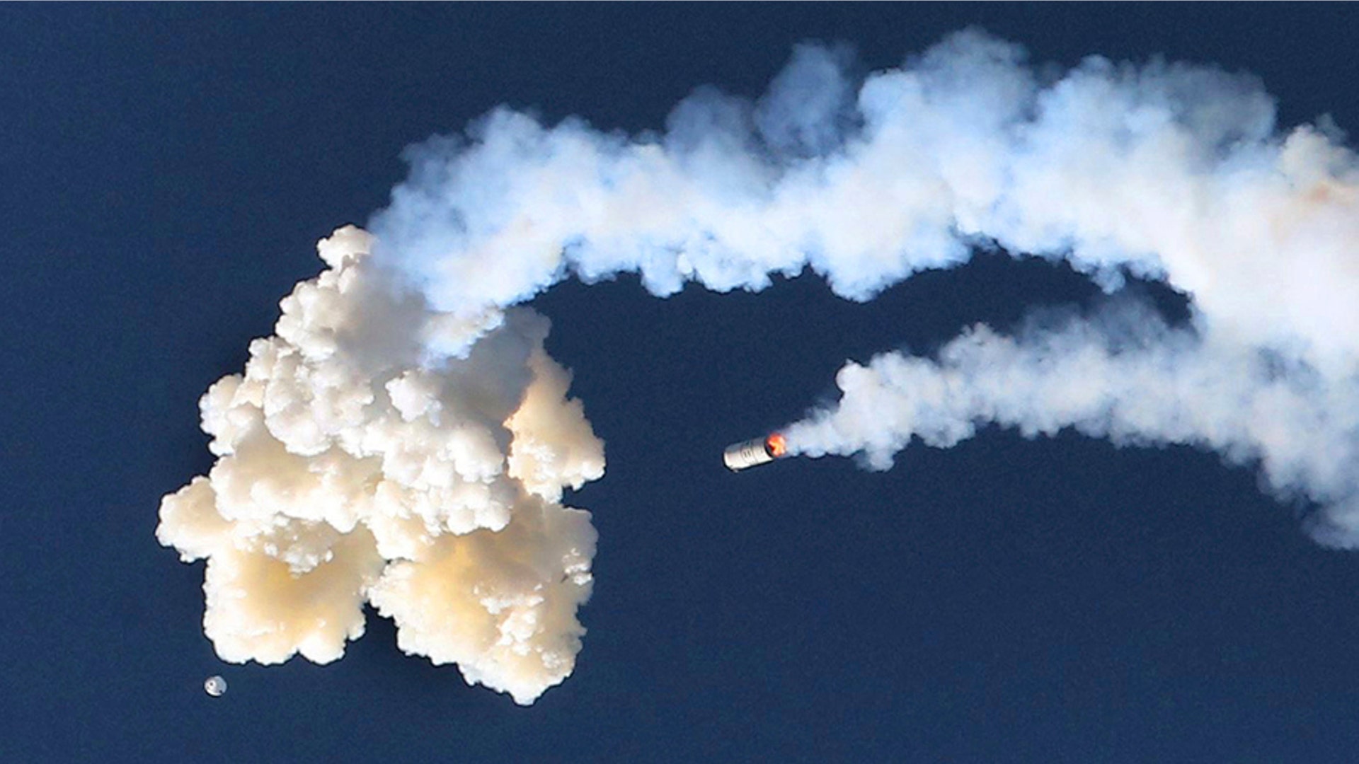 The Orion test capsule and a Minotaur 4 booster rocket, fall to the Earth during a full-stress launch abort test by NASA in Cape Canaveral, Fla., July 2, 2019. 