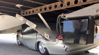 Driver suffers minor injuries after car gets wedged under truck