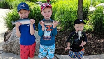 Mom doesn't realize kid shoved a rubber fish in his mouth in family photo
