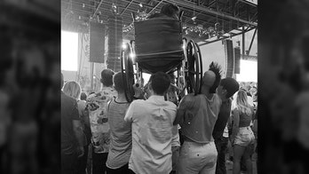 Weezer fan in wheelchair held up by concertgoers in North Dakota