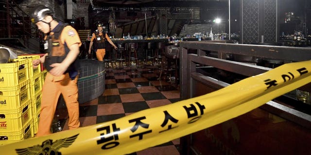 Rescue workers walk to inspect a collapsed internal balcony at a nightclub in Gwangju, South Korea, Saturday, July 27, 2019. Members of the U.S. national water polo team were in a South Korean nightclub on Saturday when an internal balcony collapsed, killing at least one person. (Associated Press)