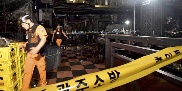 Rescue workers walk to inspect a collapsed internal balcony at a nightclub in Gwangju, South Korea, Saturday, July 27, 2019. Members of the U.S. national water polo team were in a South Korean nightclub on Saturday when an internal balcony collapsed, killing at least one person. (Associated Press)