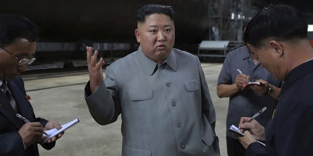 In this undated photo provided on Tuesday, July 23, 2019, by the North Korean government, North Korean leader Kim Jong Un, center, speaks while inspecting a newly built submarine to be deployed soon, at an unknown location in North Korea.