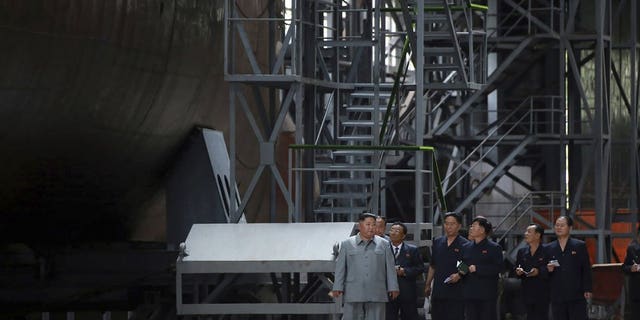In this undated photo provided on Tuesday, July 23, 2019, by the North Korean government, North Korean leader Kim Jong Un, left, inspects a newly built submarine to be deployed soon, at an unknown location in North Korea.