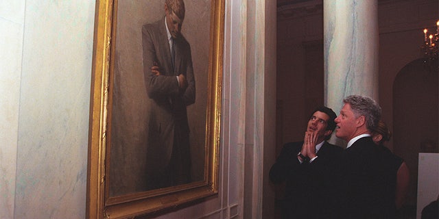 Tổng thống Clinton đưa John F. Kennedy Jr. và Carolyn Bessette đi tham quan Nhà Trắng nơi họ dừng chân và chiêm ngưỡng bức chân dung của Tổng thống Kennedy Kennedy.