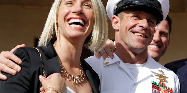 Navy Special Operations Chief Edward Gallagher, left, and his wife, Andrea Gallagher smile after leaving a military court on Naval Base San Diego, Tuesday, July 2, 2019, in San Diego. A military jury acquitted a decorated Navy SEAL of premeditated murder Tuesday in the killing of a wounded Islamic State captive under his care in Iraq in 2017. (AP Photo/Gregory Bull)