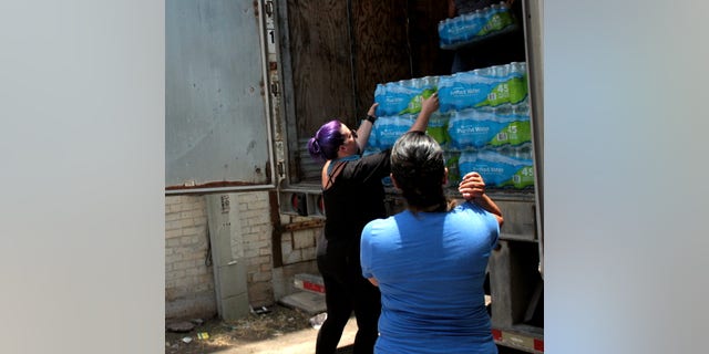 Destiny Herndon-De La Rosa, New Wave Feminists, unloads water at respite center in McAllen, Texas.