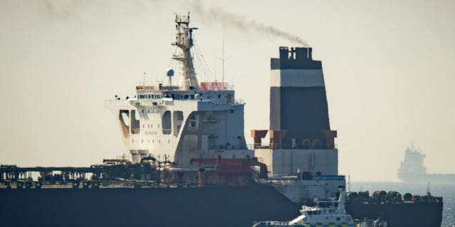 Royal Marine patrol vessel is seen beside the Grace 1 super tanker in the British territory of Gibraltar, Thursday, July 4, 2019. Authorities in Gibraltar said they intercepted Thursday an Iranian supertanker believed to be breaching European Union sanctions by carrying a shipment of Tehran's crude oil to war-ravaged Syria.