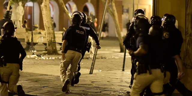 Riot control units patrol the street during clashes in San Juan, Puerto Rico, on Monday.