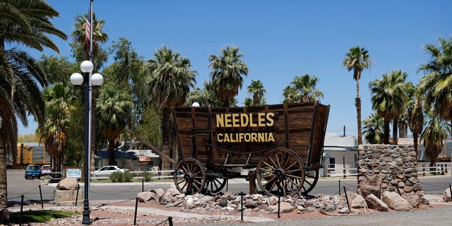 A sign adorns a historic wagon along old Route 66 in Needles, California. (Associated Press)