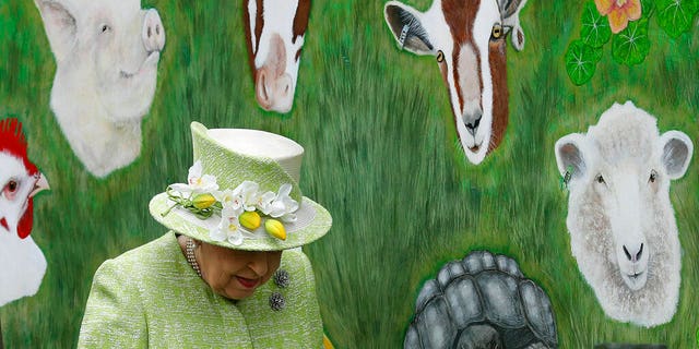 Britain's Queen Elizabeth II walks by an animal mural, during a visit to Gorgie City Farm in Edinburgh, Scotland.