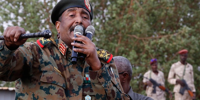 FILE - In this June 29, 2019, file photo, Sudanese Gen. Abdel-Fattah Burhan, head of the military council, speaks during a military-backed rally, in Omdurman district, west of Khartoum, Sudan. An African Union envoy says Sudan's ruling military council and the country's pro-democracy movement have reached a power-sharing agreement, including a timetable for a transition to civilian rule. Mohammed el-Hassan Labat said early Friday, July 5, that both sides agreed to form a joint sovereign council that will rule the country for "three years or a little more." The sides agreed to five seats for the military and five for civilians with an additional seat going to a civilian with military background.(AP Photo/Hussein Malla, File)