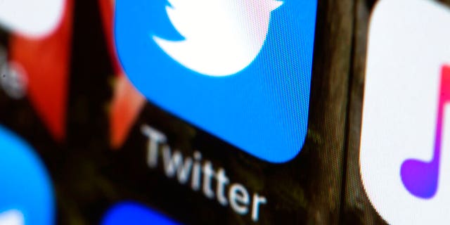 FILE - This April 26, 2017, file photo shows the Twitter app on a mobile phone in Philadelphia.  Twitter will now prohibit hate speech that targets religious groups using dehumanizing language. (AP Photo/Matt Rourke, File)