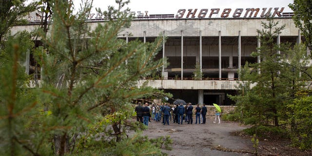 Ukrainas President Volodymyr Zelenskiy och andra tjänstemän besöker den övergivna staden Prypyat cirka 3 kilometer (1,86 miles) från Tjernobyl i Prypyat , Ukraina, onsdagen den 10 juli 2019. En struktur byggd för att begränsa radioaktivt damm från kärnreaktorn i mitten av Tjernobylkatastrofen 1986 avslöjades formellt på onsdagen.(Ukrainas Presidentpresstjänst via AP)